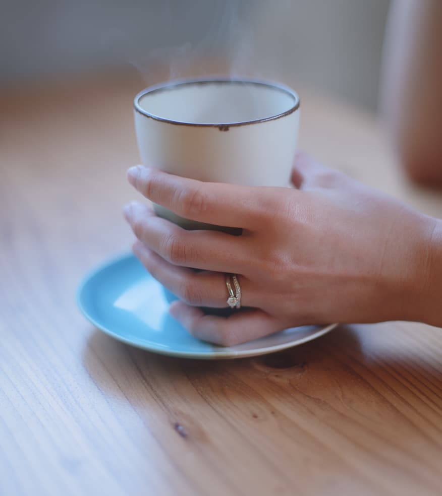 琉球杢目　女性の左手に輝く沖縄ミンサー模様が施された婚約指輪と結婚指輪　