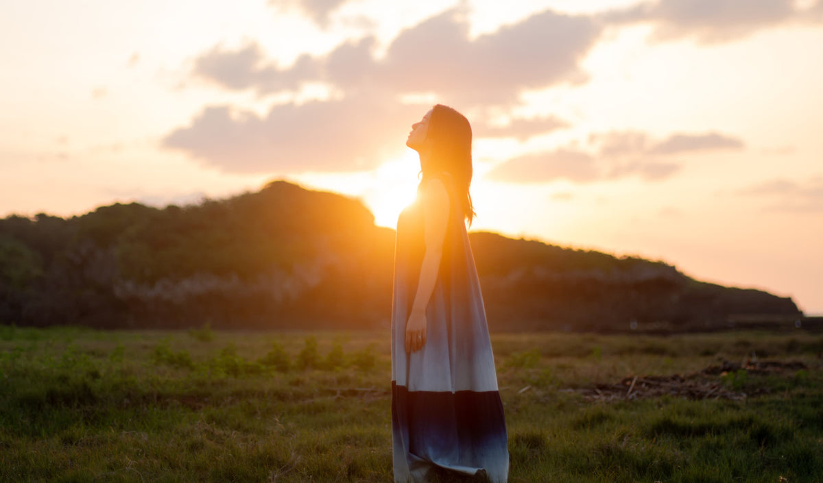 琉球杢目　横を向く女性の左手に光る沖縄ミンサー模様が刻まれた結婚指輪　婚約指輪　
